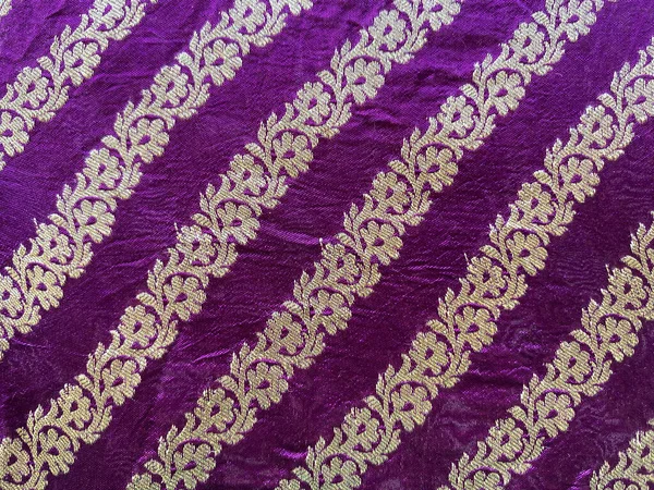 Derin mor ipek kumaşın dikey sarmaşık kenarı, ince dokusunu ve zarif işçiliğini vurguluyor..