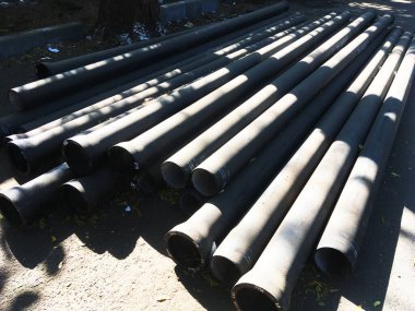 Yığılmış kanalizasyon boruları, dairesel açıklıkları, ritmik geometrik desenler yaratıyor..