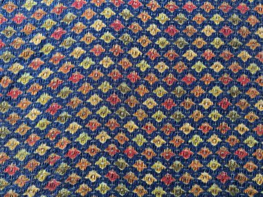 Koyu mavi şifon kumaşa basılmış küçük çok renkli Babür motifleri.