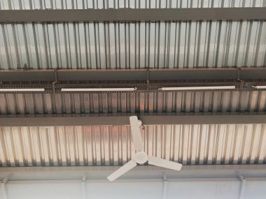Oluklu Metal Çatı Altındaki Beyaz Elektrikli Tavan Fanı