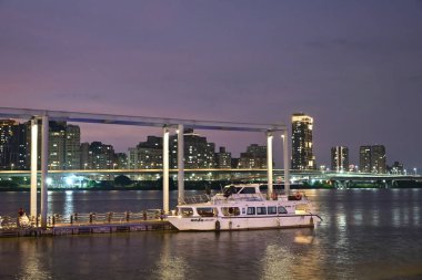 Tayvan - 11 Ekim 2025: Tamsui Nehri 'ndeki tarihi Dadaocheng Rıhtımı, aydınlık Sanchong ilçe binaları sakin su, popüler tatil beldesi.