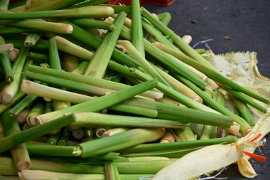Yeşil ve beyaz saplı su bambu yığınları, yaprak lifli pürüzsüz doku, derinlik katan gölgeler, koyu arka plan kontrastı, pazarda taze ürün, Tayvan.