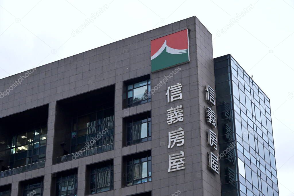 Taiwan - Oct. 26, 2025: Sinyi Realty real estate company headquarters building with vertical Chinese signage, modern multi-story architecture, glass and stone facade, corporate logo on top.