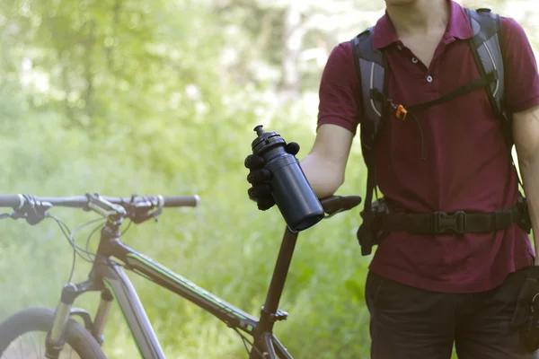 Killen på en cykel med en flaska utomhus — Stockfoto