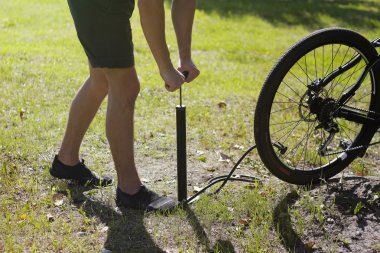 Bir bisiklet Lastik Şişirme. Bisikletçi bisiklet ormandaki onarır. Direksiyonu hava pompalama bisikletçi. Motorcu bir bisiklet pompası kullanır. Bisiklet boş bir tekerlek hava pompalama.