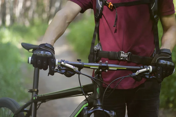 Man i handskar med cykeln i skogen — Stockfoto