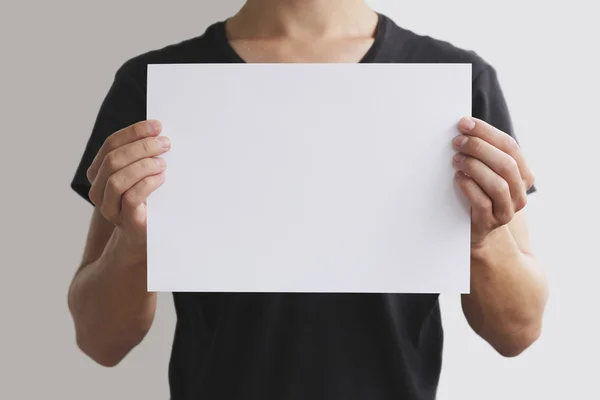 Man holding white A4 paper horizontally — Stock Photo, Image