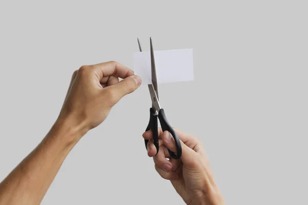 Χέρι Κόψτε το χαρτί με το ψαλίδι. Απομονωμένα σε γκρι φόντο — Φωτογραφία Αρχείου