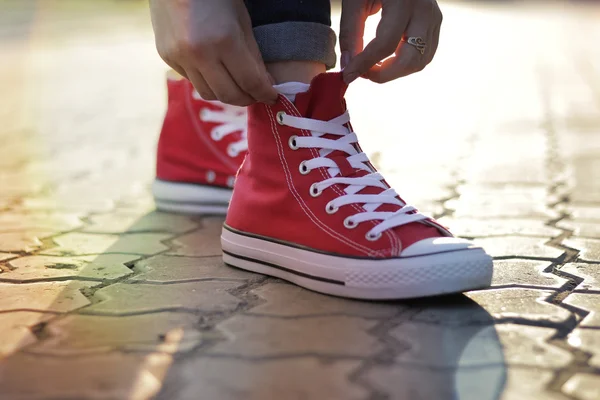 Завязывать шнурки на кроссовках в парке — стоковое фото