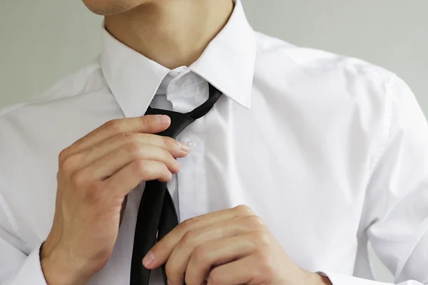Empresário de camisa branca amarrando a gravata — Fotografia de Stock