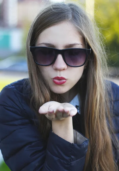 Jovem atraente bela mulher em óculos de sol pretos mostrando beijo de ar — Fotografia de Stock