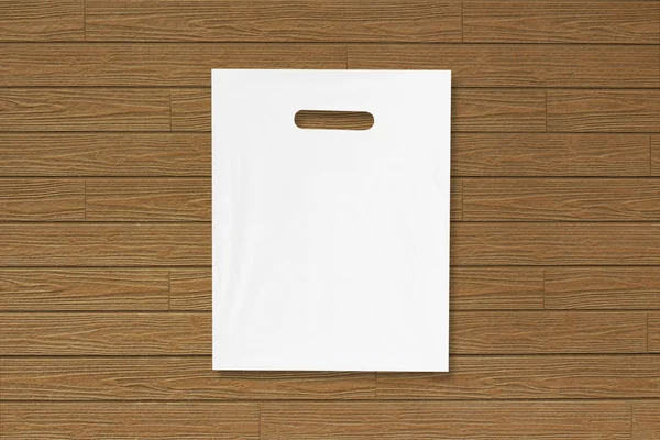 Pustą plastikową torbę makieta na drewnianej podłodze. Pusty biały Nakrywki — Zdjęcie stockowe