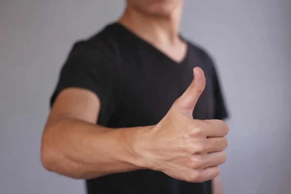 Joven mostrando el pulgar hacia arriba. Aislado sobre fondo gris —  Fotos de Stock