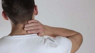 Bir adamın boynundaki ağrı. Gri bir arkaplanda.