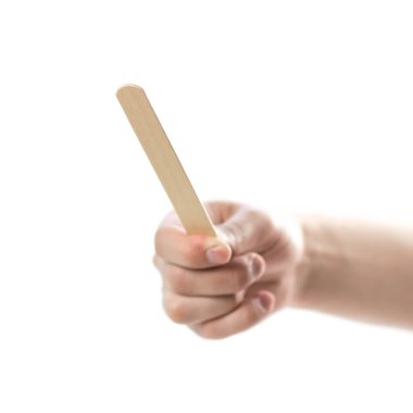 The hand holds wooden spatulas. Close up. Isolated on a white background.