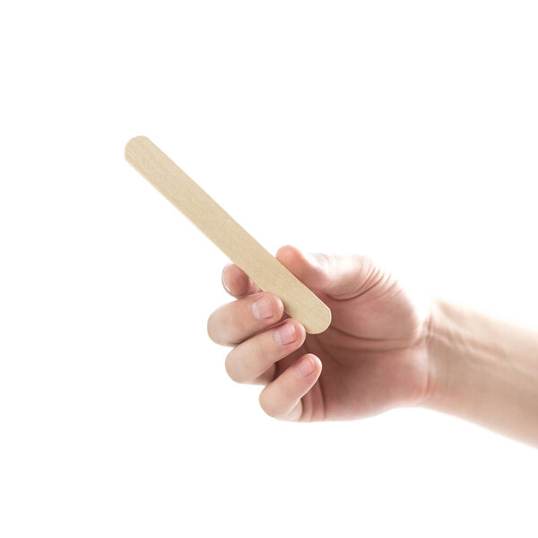 The hand holds wooden spatulas. Close up. Isolated on a white background.