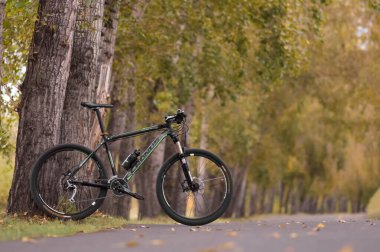 KRASNOYARSK, RUSSIA - 15 Eylül 2021: Sarı yaprakların arasında siyah bir dağ bisikleti. Sonbaharda bisiklet sürmek.
