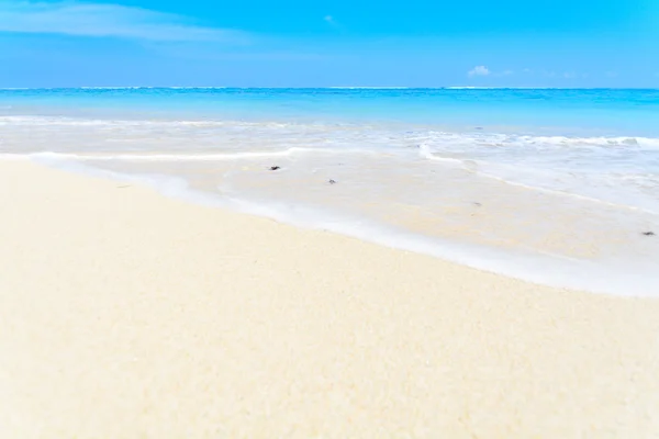 Uma onda a lavar-se sobre a costa arenosa . — Fotografia de Stock