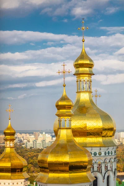 Ortodoks Kilisesi 'nin güzel sarı ve altın kubbeleri mavi gökyüzünün ve şehrin arka planına karşı. Kiev-Pechersk Lavra Katedrali 'nin Kubbeleri.