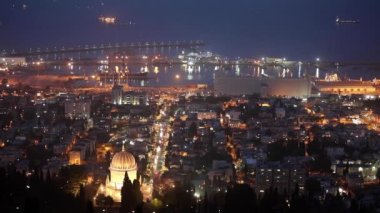 Hayfa 'daki Bahai Tapınağı' nın altın kubbesi gece ışıklarıyla aydınlatıldı. Geceleri şehirde arabalar geziyor..