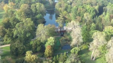 Yazın parkın üzerinde güzel bir uçuş. Yeşil yapraklı ağaçlar. İnsanlar yeşil bir çayırda yürüyorlar. Güneşli hava.