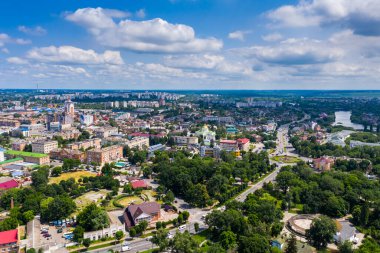 Şehrin güzel yaz manzarası. Çatı evleri, yollar, arabalar, yeşil yapraklı ağaçlar..