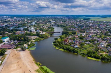 Şehrin güzel yaz manzarası. Çatı evleri, yollar, arabalar, yeşil yapraklı ağaçlar..