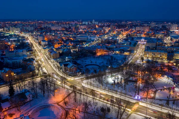 Beautiful evening top view of the city. Evening, night illumination in the city. Winter city in the snow.