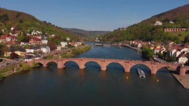 Nehrin üzerindeki yaya köprüsü. Heidelberg kalesinin ve şehrin eski kısmının güzel manzarası. Bahar. Ağaçlarda yeşil yapraklar. Nekka Nehri. Güzel dağlar.