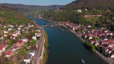 Nehrin üzerindeki yaya köprüsü. Heidelberg kalesinin ve şehrin eski kısmının güzel manzarası. Bahar. Ağaçlarda yeşil yapraklar. Nekka Nehri. Güzel dağlar.