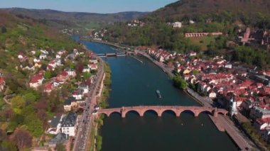 Nehrin üzerindeki yaya köprüsü. Heidelberg kalesinin ve şehrin eski kısmının güzel manzarası. Bahar. Ağaçlarda yeşil yapraklar. Nekka Nehri. Güzel dağlar.