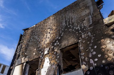 - Savaş. Rus hava saldırılarının barışçıl bir Ukrayna şehrine yaptığı saldırıdan sonra. Bir hastane ve bir dinlenme merkezi yok edildi. Dairesel yanık izleri ve yanmış binadan arta kalan kalıntılarla yanmış bir duvar..