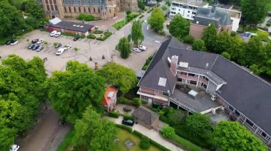 Gotik kilisesi, modern binaları, ağaç sıralı caddeleri ve tarihi mimari ile yaya dostu şehir planlama arasında çelişen bisiklet yolları olan Avrupa şehri manzarası..