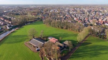 Hollanda 'nın yarı kırsal bölge çiftliği, kanal, ağaçlık yol ve yoğun şehir manzarası arazi kullanımının tarımdan banliyö gelişimine geçişini gösteriyor.