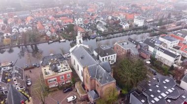 Hollanda Kanal Kilisesi 'nin havadan görünüşü altın değirmen, geometrik çatı çatısı modern bina, tekne ve kaldırımlı caddeler yoğun kentsel yerleşim planı ve mirası harmanlıyor..