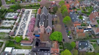 Avrupa 'nın tarihi kilisesinin havadan görünüşü, uzun çan kulesi çapaları, kırmızı çatılı evler, ağaçlarla kaplı sokaklar, çiçek açan bahçeler ve mezarlıklar, sakin bir ilkbahar manzarası oluşturuyor..
