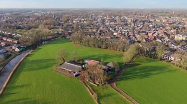 Hollanda 'nın yarı kırsal bölge çiftliği, kanal, ağaçlık yol ve yoğun şehir manzarası arazi kullanımının tarımdan banliyö gelişimine geçişini gösteriyor.