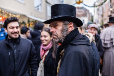 Deventer, Overijssel, Hollanda - 14.12.2025: Charles Dickens Festivali 'nde. Silindir şapkalı ve favorili adam modern kalabalığın olduğu festivallerde Viktorya dönemi kostümü giyiyor..