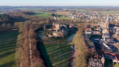 Geniş hendeği olan bir ortaçağ şatosu yüksek bir kilisenin yanında duruyor. Kümelenmiş evler, açık araziler, ağaçlık yollar ve ormanlarla çevrili. Uyumlu tarihi bir manzara oluşturuyor..