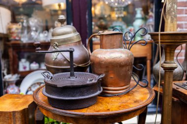 Antika öğütücü, bakır sürahi ve pirinç vazo cam masa üzerinde seramik ve nostaljik sıcak eski fotoğraflar sergilenir..