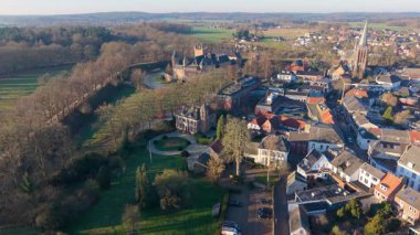 Hendek, kilise kulesi, yoğun evler ve uzak rüzgar türbinleriyle Hollanda kentinin havadan görünüşü, ortaçağ mirasıyla modern sürdürülebilirliği harmanlıyor..