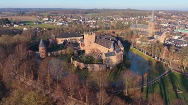 Hendek, kilise kulesi, yoğun evler ve uzak rüzgar türbinleriyle Hollanda kentinin havadan görünüşü, ortaçağ mirasıyla modern sürdürülebilirliği harmanlıyor..