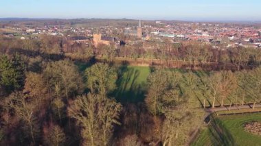 Hollanda kırsal kesiminin havadan görünüşü şato, kilise kulesi, yapraksız ağaçlar, kış tarlalarıyla çevrili yoğun evler ve kırsal-kentsel katmanlı bir bileşimin orman kenarları..