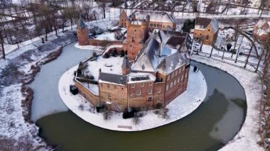 Kırmızı tuğladan kale ve donmuş ortaçağ kuleleriyle kaplı kar manzarası modern evlerle ve huzurlu kış manzarasındaki kilise kulesiyle tezat oluşturuyor..