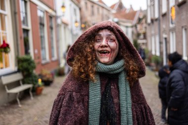 Deventer, Overijssel, Hollanda - 14.12.2025: Charles Dickens Festivali 'nde. Makyaj, soluk ten ve sokak ortamındaki tüyler ürpertici ifadeye sahip korku temalı bir karaktere yakından bakın..