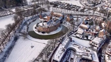 Tarihi bir kasaba, kilise kulesi, çan kulesi, tarlaları ve ağaçlarla çevrili, sakin, pitoresk manzaralı, karla kaplı bir kalenin kış manzarası..