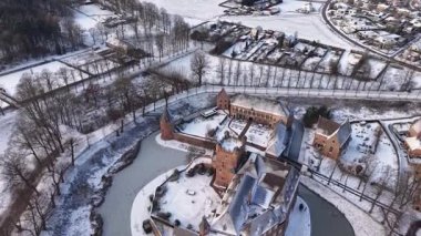Tarihi bir kasaba, kilise kulesi, çan kulesi, tarlaları ve ağaçlarla çevrili, sakin, pitoresk manzaralı, karla kaplı bir kalenin kış manzarası..