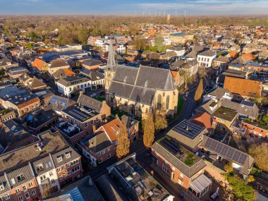 Avrupa 'nın önde gelen Gotik kilisesinin yüksek açılı hava manzarası. Yüksek kulesi, güneş panelleri olan geleneksel tuğlalı evleri ve yumuşak günbatımı gökyüzü altında manzaralı bir ufuk..