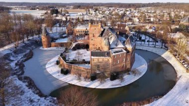 Hollanda, s-Heerenberg 'deki Huis Bergh Kalesi' nin kış manzarası. Donmuş hendekler ve parlak güneş ışığı altında karla kaplı manzarayla çevrili tuğla kuleleri olan görkemli ortaçağ kalesi..