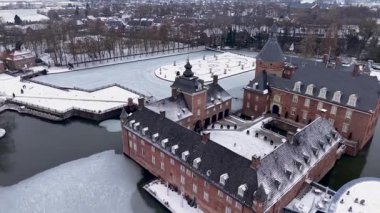 Almanya 'daki çarpıcı Burg Anholt kalesinin hava görüntüsü. Ortaçağ tuğla mimarisi, karlı bir avlu ve donmuş bahçe havuzları. Kuzey Ren-Vestfalya 'da resim gibi bir kış manzarası.